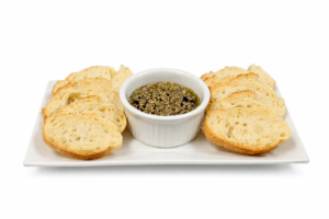 Small bowl of olive tapenade with toasted bread slices.
