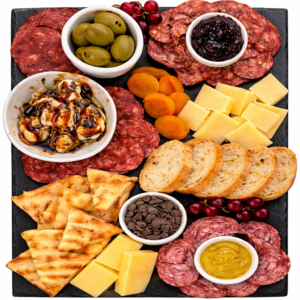 A charcuterie board with meats, cheeses, and dips.