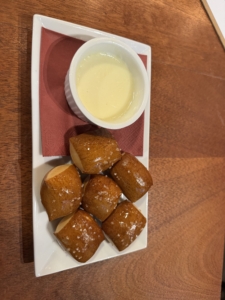 Glazed diamond-shaped pastries with a cup of tea on a wooden table.